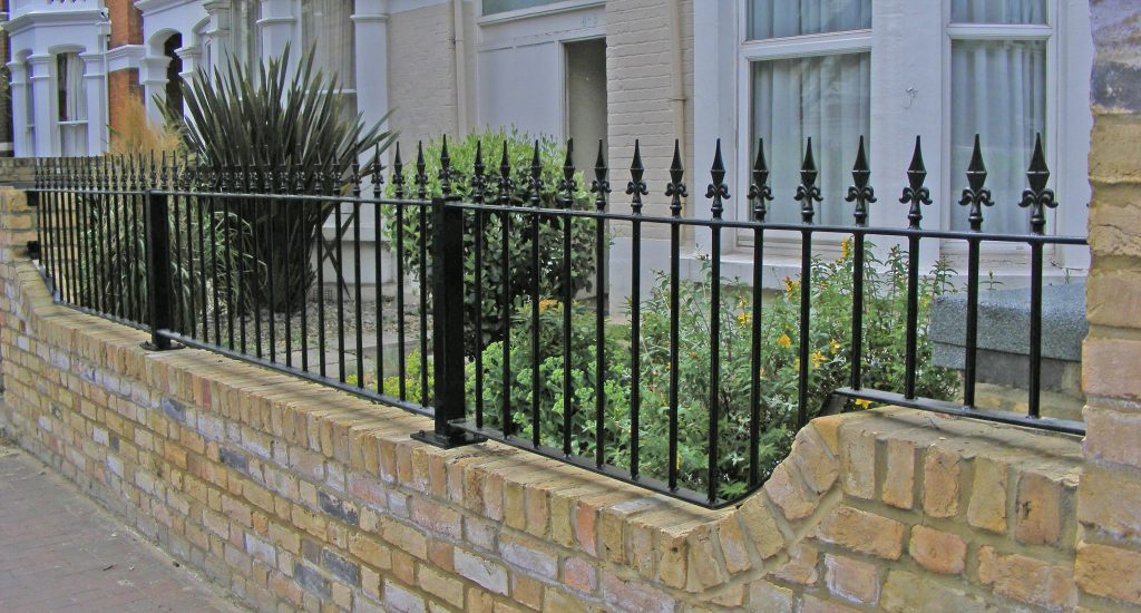 Wrought iron railing made to fit a shaped brick wall