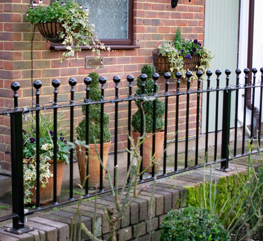 Short railings with posts on a flat brick wall