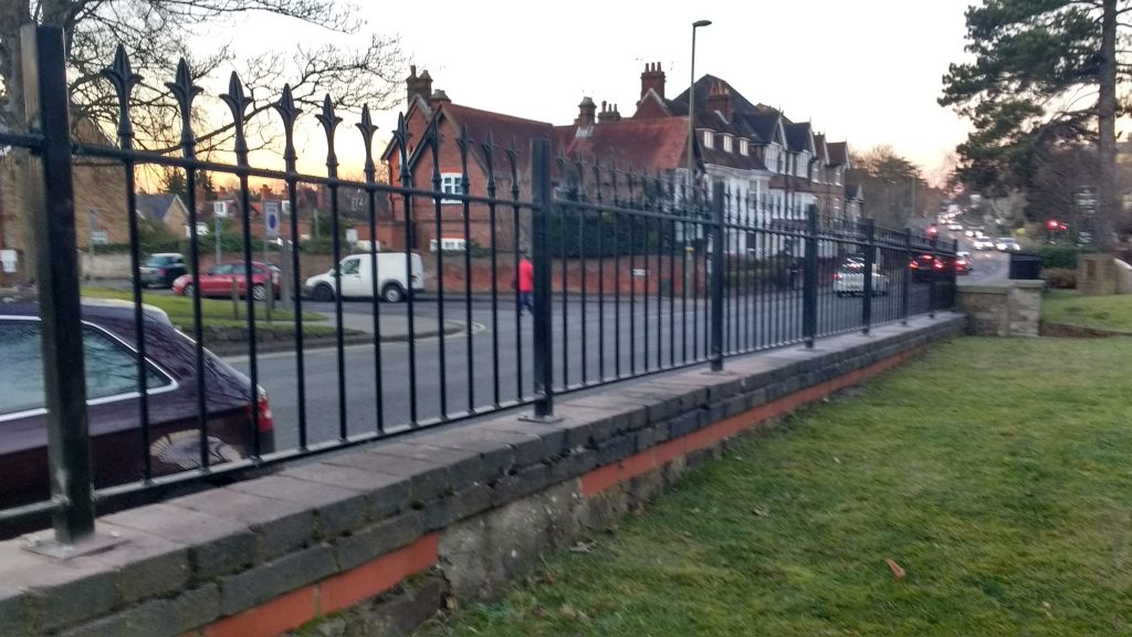 wrought iron railing on sloping wall with metal connecting posts